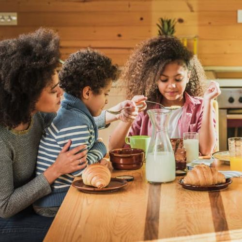 Children sitting at dining table with Mum
